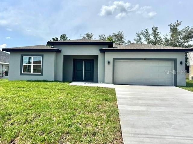 319 Anchovie Ct, Poinciana, FL 34759 - view of front of house with stucco siding, a garage, driveway, and a front lawn