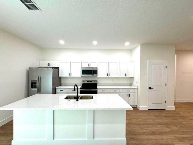 319 Anchovie Ct, Poinciana, FL 34759 - kitchen featuring appliances with stainless steel finishes, a sink, white cabinets, wood finished floors, and recessed lighting