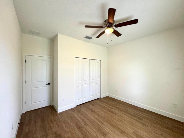 319 Anchovie Ct, Poinciana, FL 34759 - unfurnished bedroom with wood finished floors, baseboards, and a closet