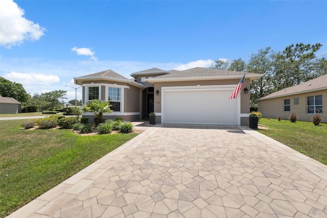 9426 Burnam Dr, Weeki Wachee, FL 34613 - view of front of house featuring decorative driveway, a front yard, stucco siding, and an attached garage