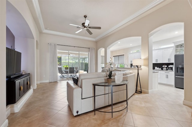 9426 Burnam Dr, Weeki Wachee, FL 34613 - living area with a ceiling fan, light tile patterned floors, ornamental molding, arched walkways, and baseboards