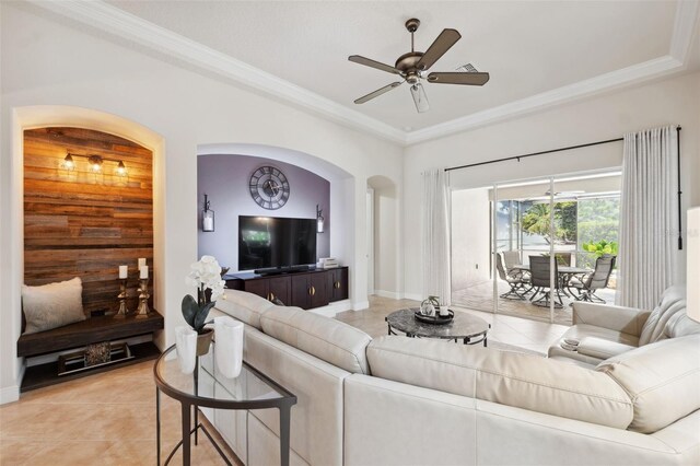 9426 Burnam Dr, Weeki Wachee, FL 34613 - living room featuring light tile patterned floors, a ceiling fan, ornamental molding, arched walkways, and baseboards