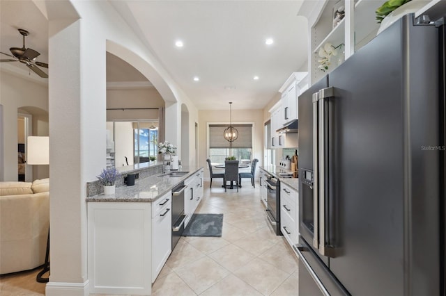 9426 Burnam Dr, Weeki Wachee, FL 34613 - kitchen with appliances with stainless steel finishes, a ceiling fan, white cabinetry, light stone countertops, and under cabinet range hood