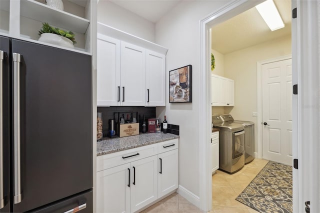 9426 Burnam Dr, Weeki Wachee, FL 34613 - laundry room with separate washer and dryer, cabinet space, and light tile patterned flooring