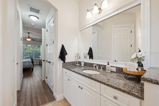 9426 Burnam Dr, Weeki Wachee, FL 34613 - bathroom featuring vanity, wood finished floors, connected bathroom, and baseboards