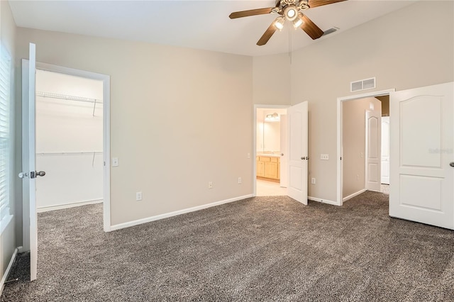 26622 Castleview Way, Wesley Chapel, FL 33544 - unfurnished bedroom with dark colored carpet, a walk in closet, baseboards, a closet, and a high ceiling