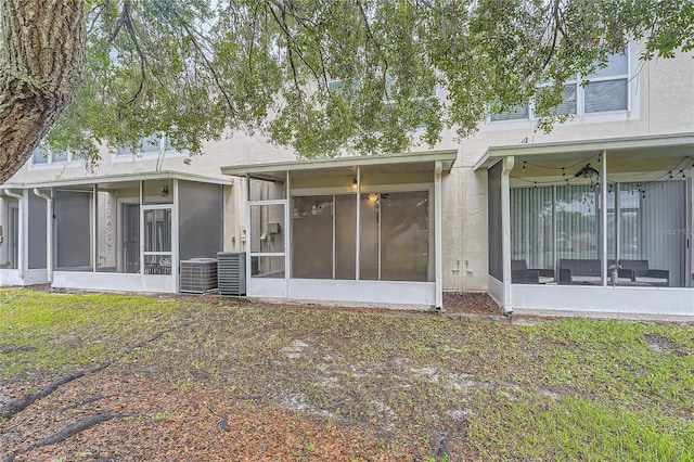 26622 Castleview Way, Wesley Chapel, FL 33544 - rear view of property featuring a sunroom, central AC unit, and stucco siding
