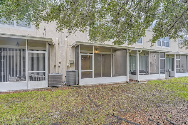 26622 Castleview Way, Wesley Chapel, FL 33544 - back of property featuring a sunroom, central air condition unit, and stucco siding