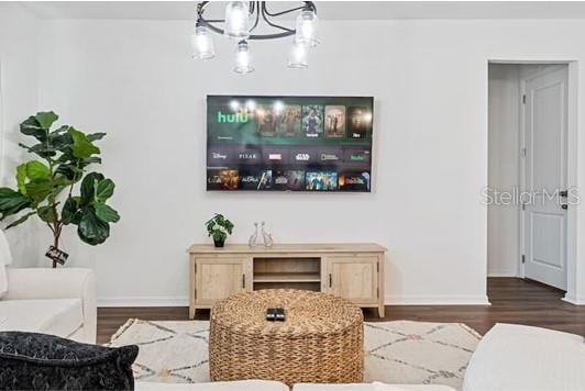 2363 Lancashire St, Davenport, FL 33896 - living room featuring a chandelier, baseboards, and wood finished floors