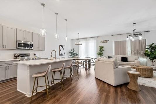 2363 Lancashire St, Davenport, FL 33896 - kitchen featuring appliances with stainless steel finishes, a chandelier, dark wood-style floors, and open floor plan