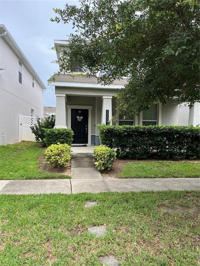 11097 N Folklore St, Winter Garden, FL 34787 - view of front of house with stucco siding, a front lawn, and roof with shingles