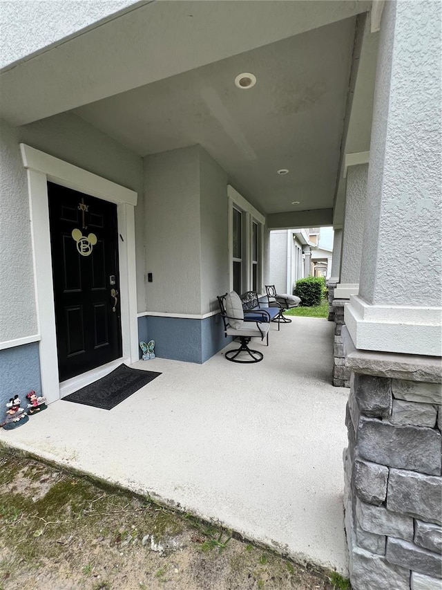 11097 N Folklore St, Winter Garden, FL 34787 - doorway to property featuring stucco siding and covered porch
