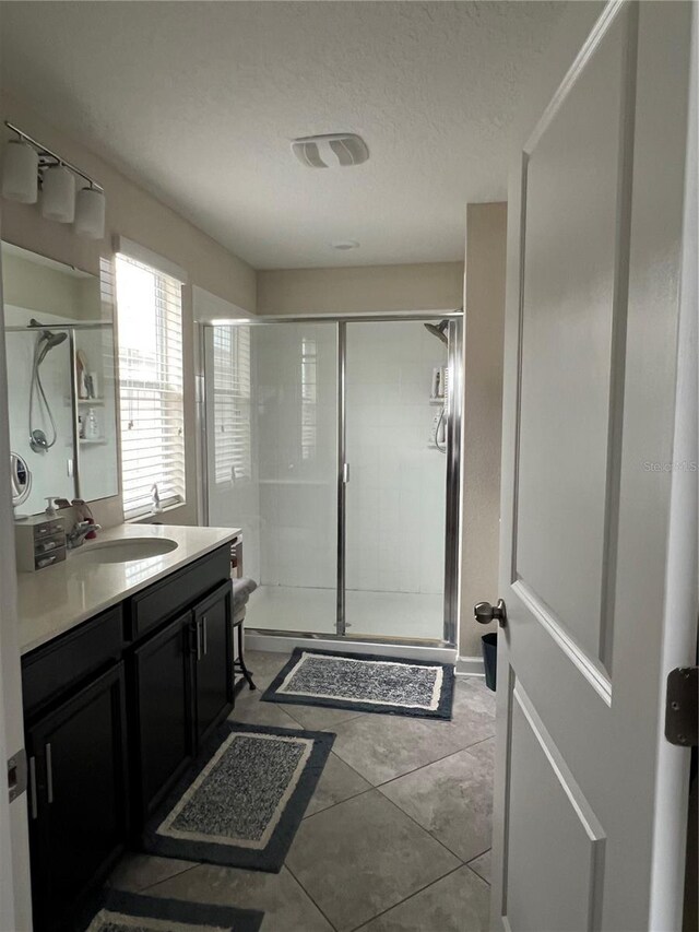 11097 N Folklore St, Winter Garden, FL 34787 - bathroom with a shower stall, vanity, tile patterned flooring, and a textured ceiling