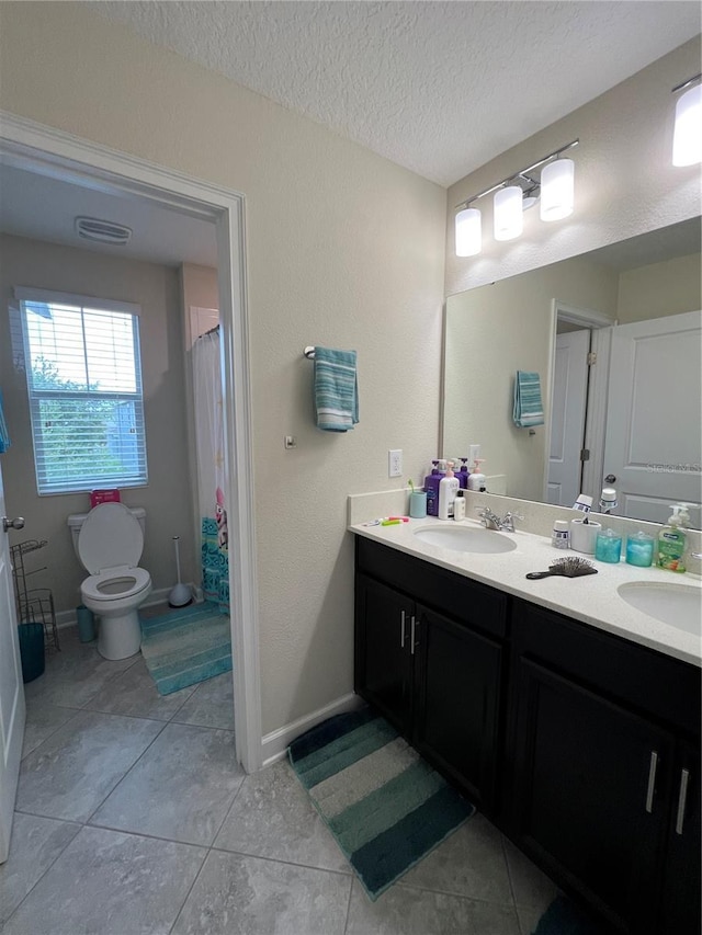 11097 N Folklore St, Winter Garden, FL 34787 - bathroom featuring double vanity, toilet, tile patterned floors, a textured ceiling, and baseboards