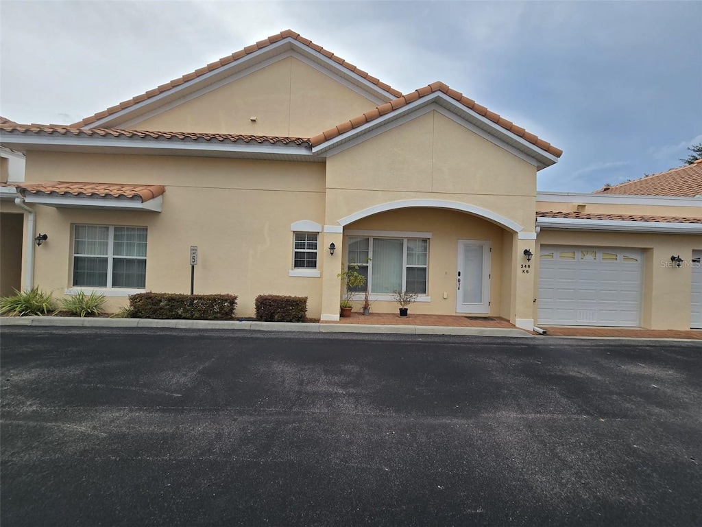 346 David Walker Dr Unit K-6, Tavares, FL 32778 - view of front of property featuring stucco siding, a tiled roof, an attached garage, and driveway