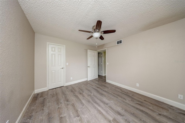 420 Forestway Cir Unit 306, Altamonte Springs, FL 32701 - unfurnished bedroom with wood finished floors, a textured ceiling, baseboards, and a ceiling fan