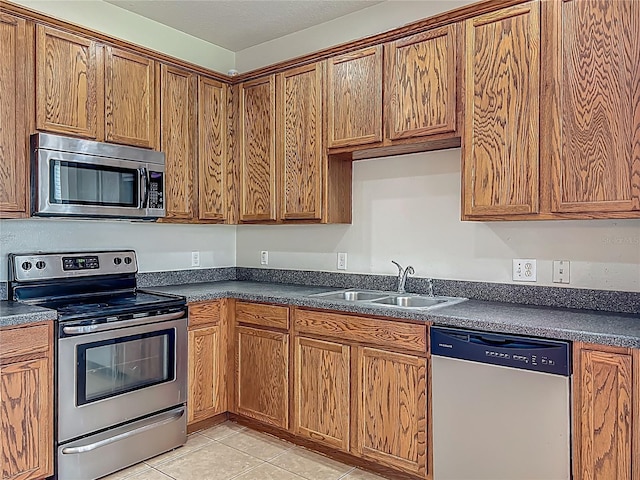2005 Compass Flower Way, Ocoee, FL 34761 - kitchen with stainless steel appliances, a sink, dark countertops, and brown cabinets