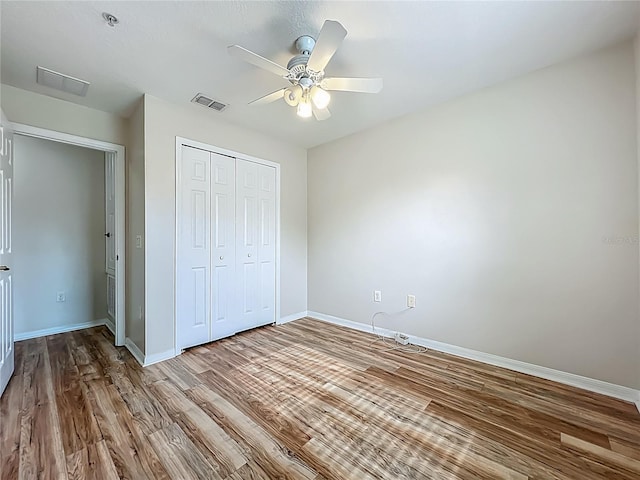 2005 Compass Flower Way, Ocoee, FL 34761 - unfurnished bedroom with wood finished floors, baseboards, a closet, and a ceiling fan