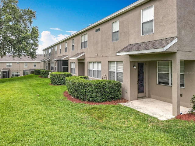 2005 Compass Flower Way, Ocoee, FL 34761 - back of house featuring stucco siding, a lawn, a shingled roof, and a patio