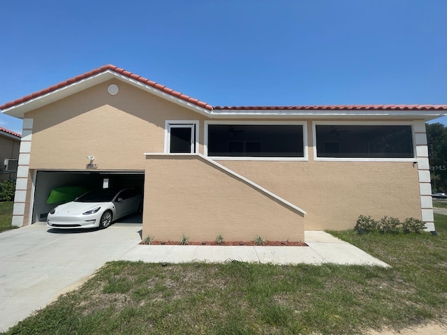 4865 S Tromp Loop, Homosassa, FL 34448 - view of property exterior with stucco siding, a tiled roof, driveway, and a garage