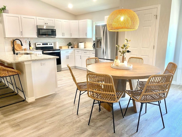 4865 S Tromp Loop, Homosassa, FL 34448 - kitchen with stainless steel appliances, a sink, backsplash, white cabinets, and a peninsula