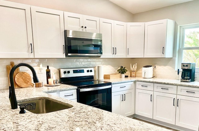 4865 S Tromp Loop, Homosassa, FL 34448 - kitchen with stainless steel microwave, range with electric cooktop, a sink, and white cabinetry