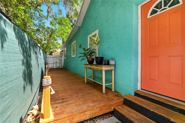 318 Palm St, New Smyrna Beach, FL 32168 - property entrance featuring stucco siding and a wooden deck