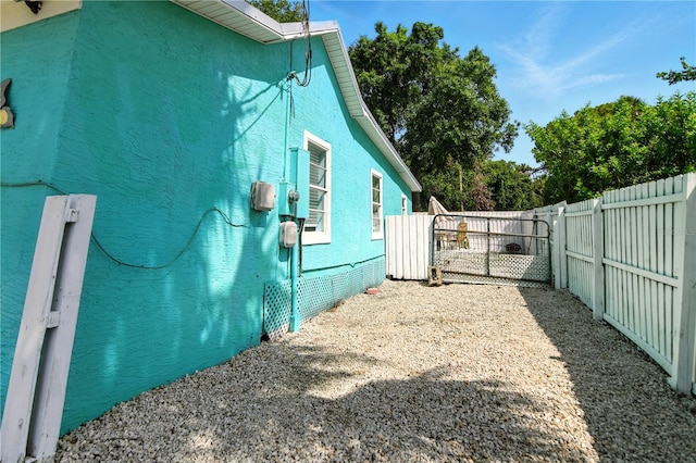 318 Palm St, New Smyrna Beach, FL 32168 - view of side of home featuring a fenced backyard, a gate, and stucco siding