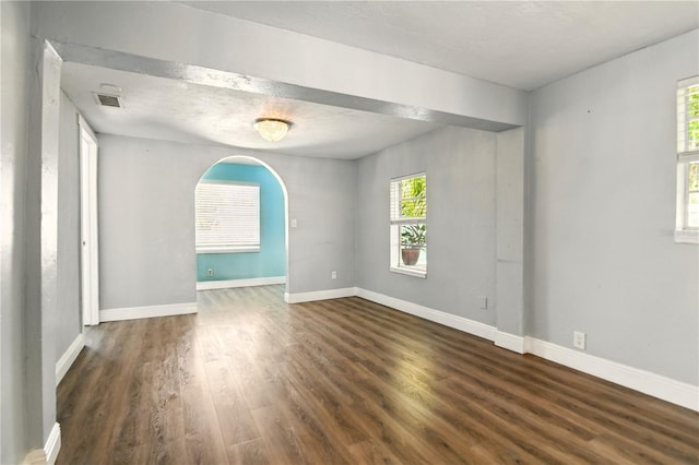 318 Palm St, New Smyrna Beach, FL 32168 - unfurnished room with wood finished floors, arched walkways, and baseboards