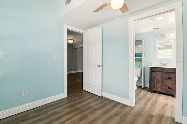 318 Palm St, New Smyrna Beach, FL 32168 - unfurnished bedroom with wood finished floors, baseboards, a sink, and ceiling fan
