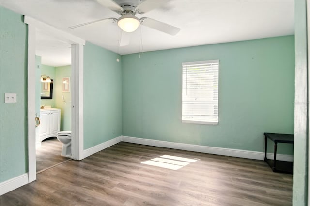 318 Palm St, New Smyrna Beach, FL 32168 - unfurnished bedroom featuring wood finished floors, baseboards, ceiling fan, and ensuite bath
