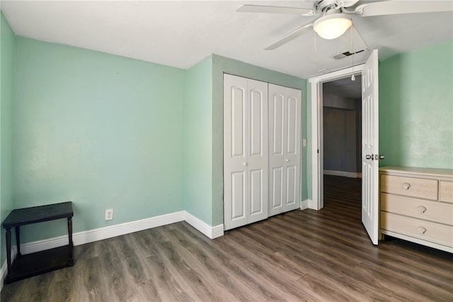 318 Palm St, New Smyrna Beach, FL 32168 - unfurnished bedroom featuring dark wood-type flooring, baseboards, a closet, and ceiling fan