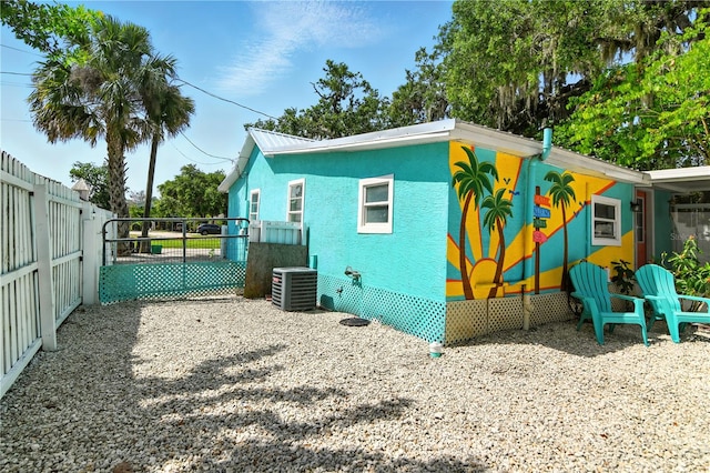 318 Palm St, New Smyrna Beach, FL 32168 - view of side of home with cooling unit, a gate, and stucco siding