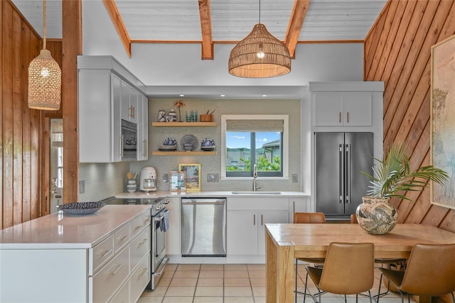 4365 S Atlantic Ave Unit B8, New Smyrna Beach, FL 32169 - kitchen featuring premium appliances, a sink, light countertops, light tile patterned floors, and wood walls