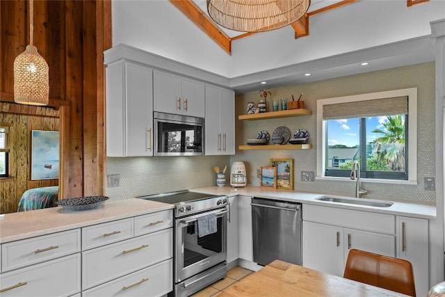 4365 S Atlantic Ave Unit B8, New Smyrna Beach, FL 32169 - kitchen featuring stainless steel appliances, a sink, decorative backsplash, light countertops, and white cabinets