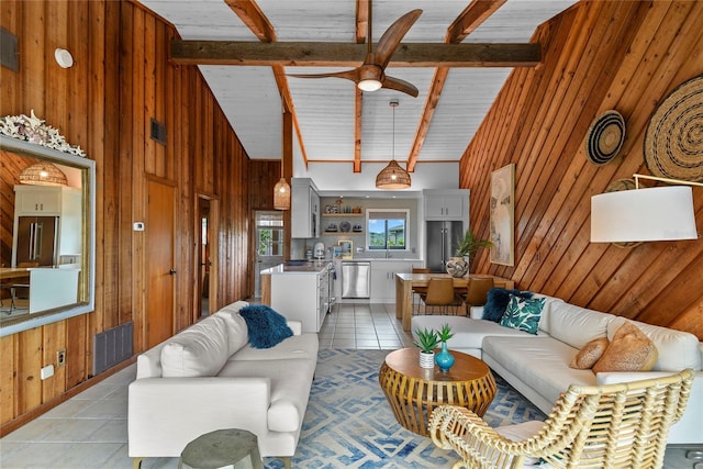 4365 S Atlantic Ave Unit B8, New Smyrna Beach, FL 32169 - living area featuring wood walls, light tile patterned flooring, high vaulted ceiling, a ceiling fan, and beam ceiling