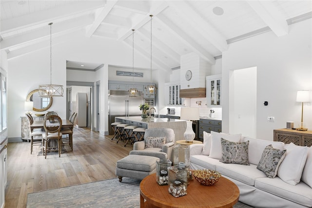 507 S Pine St, New Smyrna Beach, FL 32169 - living area featuring a chandelier, light wood-style flooring, beam ceiling, and high vaulted ceiling
