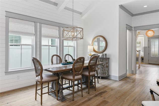 507 S Pine St, New Smyrna Beach, FL 32169 - dining area with a chandelier, healthy amount of natural light, beamed ceiling, and light wood-style floors