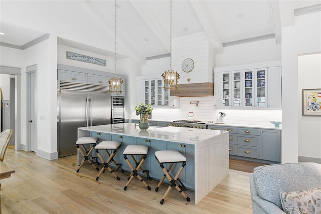 507 S Pine St, New Smyrna Beach, FL 32169 - kitchen featuring built in refrigerator, a kitchen breakfast bar, light wood finished floors, a chandelier, and a center island