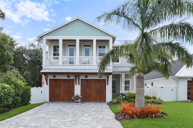 507 S Pine St, New Smyrna Beach, FL 32169 - view of front of home featuring a garage, decorative driveway, stucco siding, a gate, and a standing seam roof