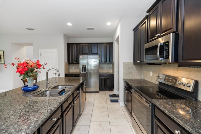 1431 Leitrim Loop, Apopka, FL 32703 - kitchen with appliances with stainless steel finishes, a sink, backsplash, dark stone countertops, and recessed lighting