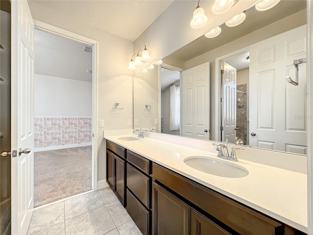 4993 Southlawn Ave, Orlando, FL 32811 - bathroom with double vanity, baseboards, and tile patterned floors