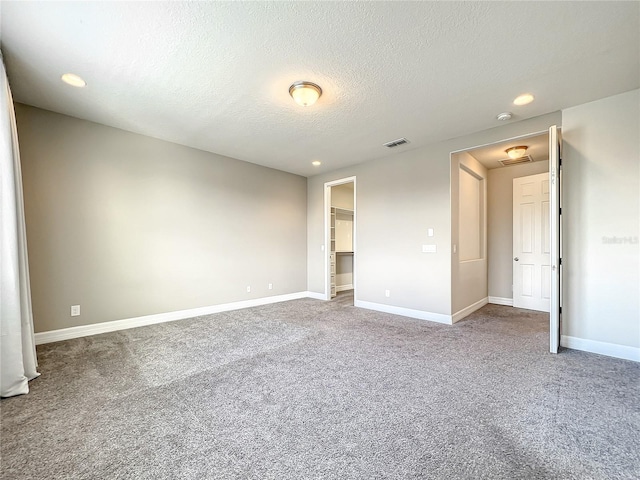 4993 Southlawn Ave, Orlando, FL 32811 - unfurnished bedroom featuring carpet, a textured ceiling, recessed lighting, baseboards, and a spacious closet