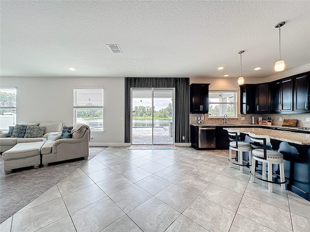 4993 Southlawn Ave, Orlando, FL 32811 - living room with light tile patterned floors, recessed lighting, a textured ceiling, and baseboards