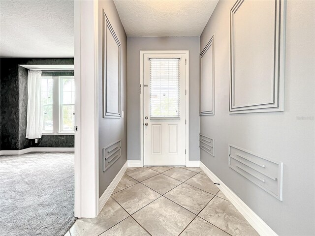 4993 Southlawn Ave, Orlando, FL 32811 - entrance foyer featuring a textured ceiling, baseboards, and light tile patterned flooring