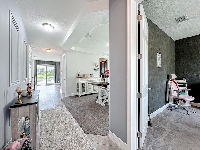 4993 Southlawn Ave, Orlando, FL 32811 - corridor featuring a textured ceiling, carpet, tile patterned flooring, and baseboards