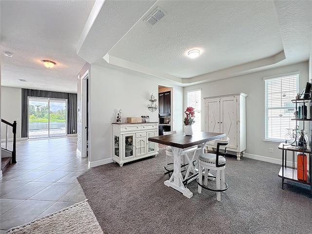 4993 Southlawn Ave, Orlando, FL 32811 - dining room with a textured ceiling, baseboards, a tray ceiling, stairway, and tile patterned floors
