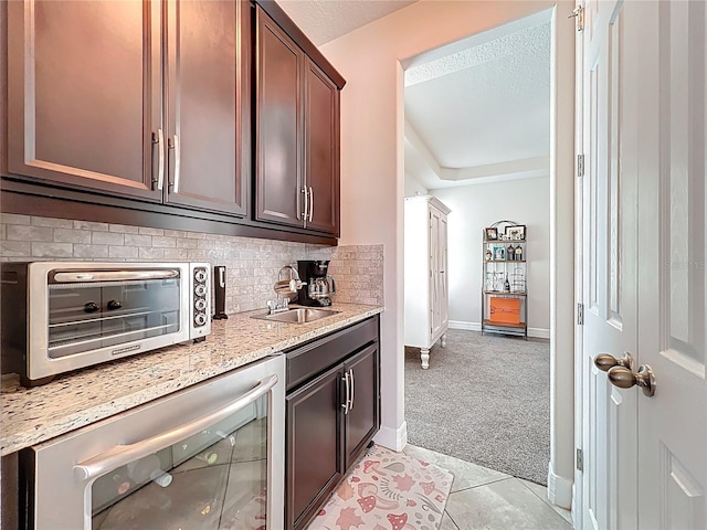 4993 Southlawn Ave, Orlando, FL 32811 - kitchen with beverage cooler, light carpet, a sink, backsplash, and baseboards