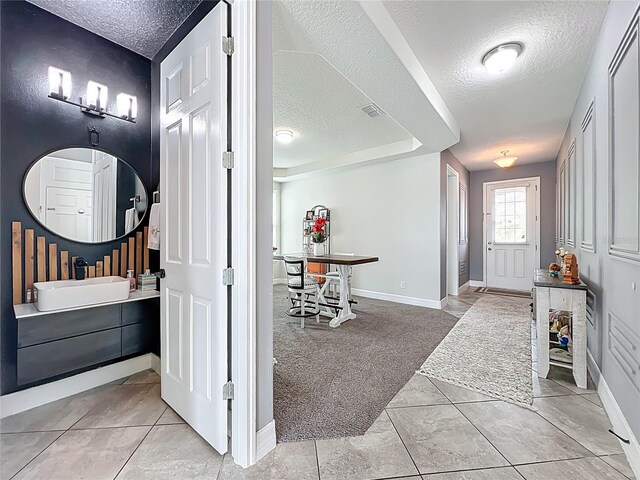 4993 Southlawn Ave, Orlando, FL 32811 - foyer with a textured ceiling, baseboards, and light colored carpet