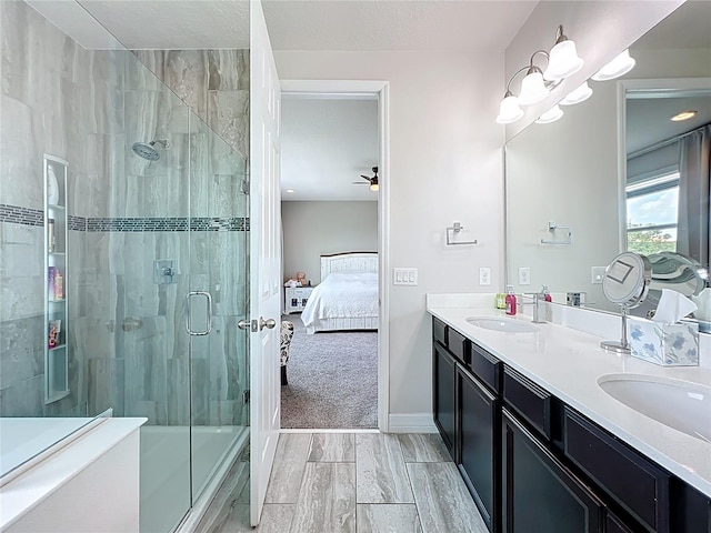 4993 Southlawn Ave, Orlando, FL 32811 - ensuite bathroom featuring a shower with door, double vanity, a ceiling fan, baseboards, and wood finished floors